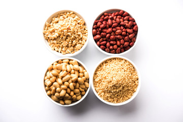 Crushed peanuts or mungfali powder with whole and roasted groundnut. Served in a bowl over moody background. Selective focus