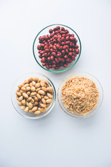 Crushed peanuts or mungfali powder with whole and roasted groundnut. Served in a bowl over moody background. Selective focus