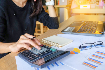 Close up of yong asian female business owner making calculations. Savings, finances and economy...