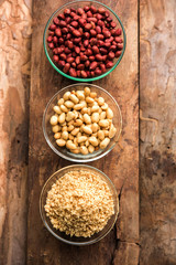 Crushed peanuts or mungfali powder with whole and roasted groundnut. Served in a bowl over moody background. Selective focus