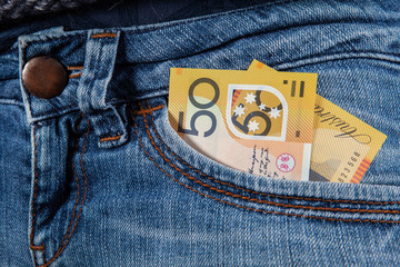 50 Australian dollars bill in front pocket of female blue jeans closeup