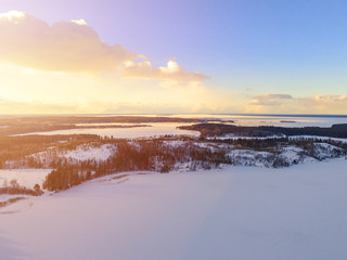 Aerial drone view of a winter landscape. Snow covered forest and lakes from the top. Sunrise in  nature from a birds eye view. Aerial photography. Aerial photo. Quadcopter. Soft lighting