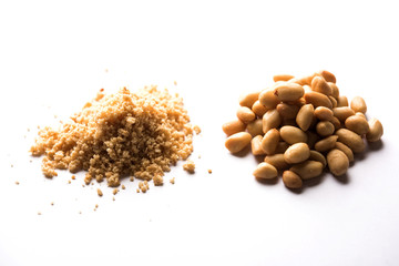 Crushed peanuts or mungfali powder with whole and roasted groundnut. Served in a bowl over moody background. Selective focus