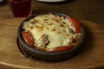 Meat in a frying pan, baked with vegetables and cheese. Dish of Mediterranean cuisine. Restaurant shooting.