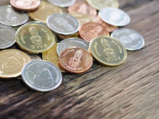 Thai new coin in King Rama 10 on wooden board with concept of finance, banking and business.