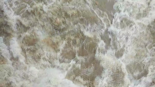 Background or texture. Slow motion of a small mountain waterfall. The mountain stream falls down on stones in a bottom.