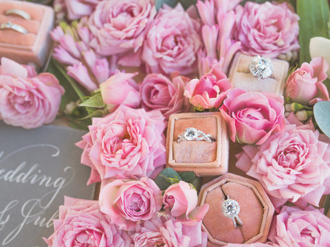 Boxes with rings lie among flowers on a table