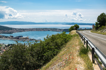 Photograph of the views from the road to Trogir in which you can see a bay with a large industrial and marine port as well as the city. Photograph taken in Trogir, Croatia.