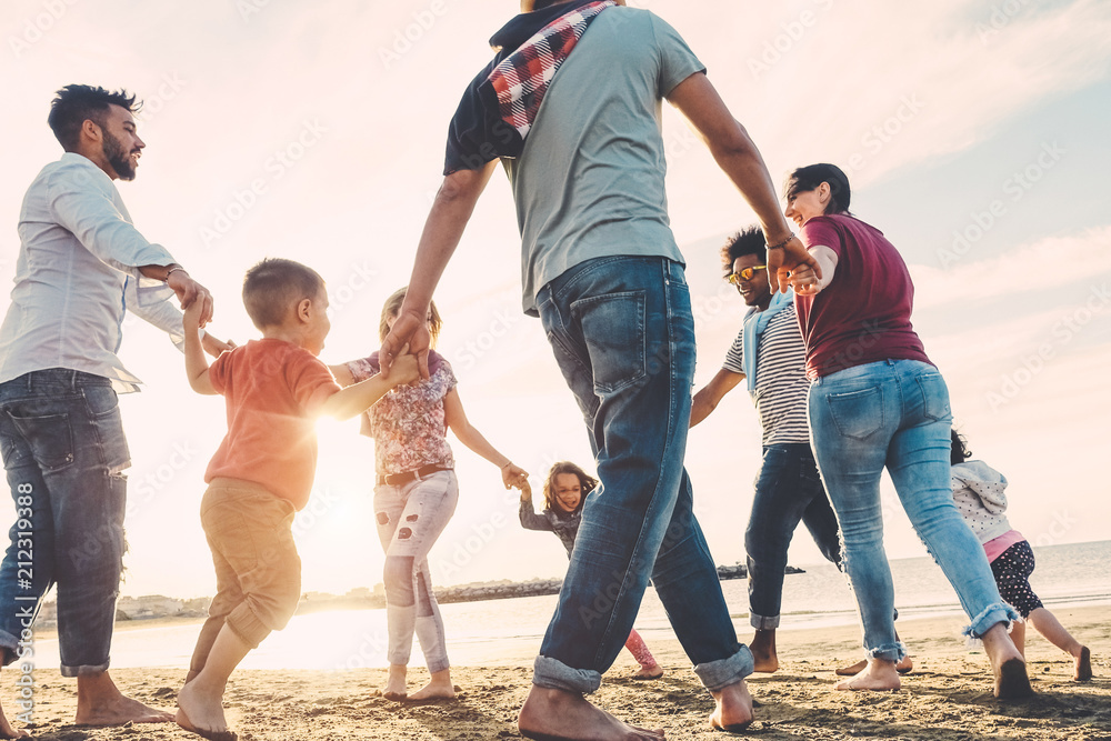 Wall mural family friends having fun on the beach at sunset