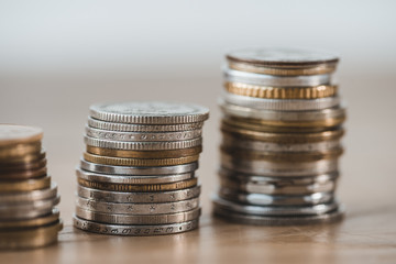 Close up of stacks of coins on wooden tabletop in financial office