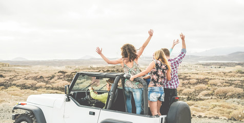 Happy tourists friends doing excursion on desert in convertible 4x4 car - Young people having fun...