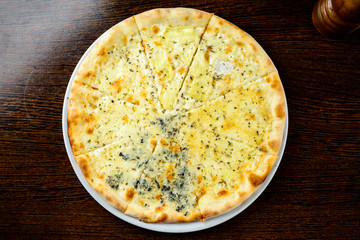 Appetizing hot Four Cheese Pizza on the table. Top view, flat la