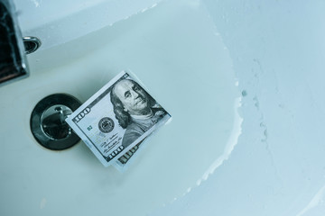 top view of dollar banknote in water in sink