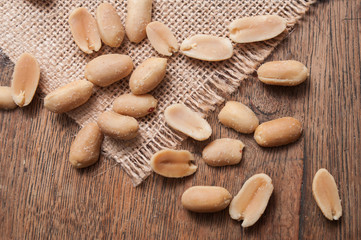 closeup of salted peanuts on wooden background on top view