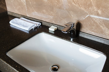 Luxury bathroom in a hotel room made of brown marble with silver details
