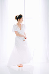 Tender elegant young bride with hairdo, hairpin and bridal makeup