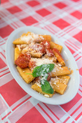 Traditional italian pasta with tomatoes, parmesan cheese and basil leaves served in local restaurant in Naples, Italy