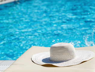 White hat left by a swimming pool. Travel