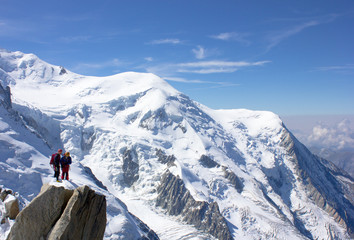 Schneebedeckter Gipfel des Dôme du Goûter und strahlend blauer Himmel des Mont-Blanc-Massivs,...