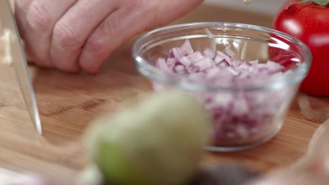 Chef slicing garlic clove with kitchen knife