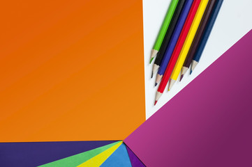 Colored paper and colored pencils for drawing lie on the table. Back to school