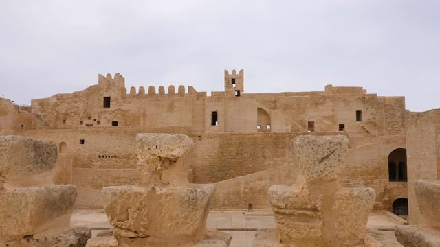 Ancient rocky walls defensive fortress Ribat in Monastir, Tunisia, crane shot