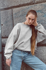 Beautiful young girl in youth sports clothes walking in the streets of the city