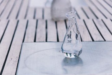 Glas Karaffe Vase auf Holztisch Minimalistisches Stilleben im Garten