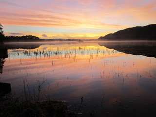 Sunrise over the mountain lake...Reflection of sunset in crystal clear water of the lake...Wolflake...Os...Norway