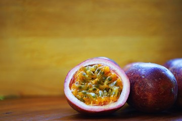 Group of passion fruit with half cut on wooden table with blur green garden background, copy space,...