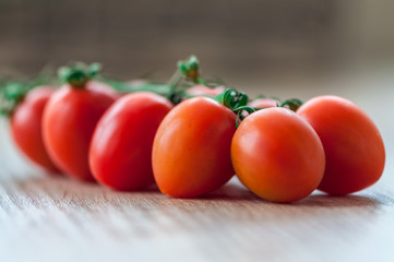 Close-up of cherry tomatoes on a wooden table. Shallow depth of field.