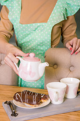  girl pours tea from a teapot