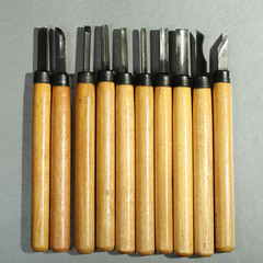 Set of wood carving knives with yellow handles on a gray background