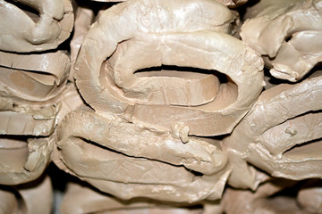 Wet white clay closeup. Abstract pieces of wet clay on the table. Sculptor sculpts pots products from white clay. Dark. Workshop pottery. Master crock. Cultural traditions. Handmade. Craft.