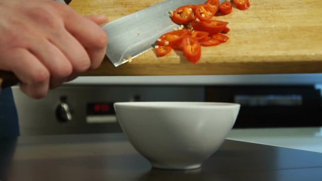 white male chef pours pepper into a plate