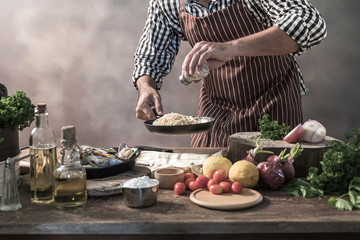 Handsome bearded cheef cook prepairing spaghetti on a kitchen.
