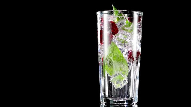 cold drink with blackberries and mint on a black background