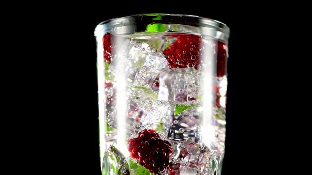 cold drink with blackberries and mint on a black background closeup