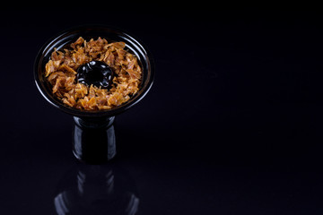 Hookah bowl with tobacco on black background