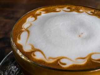 Abstract latte art coffee on wood table