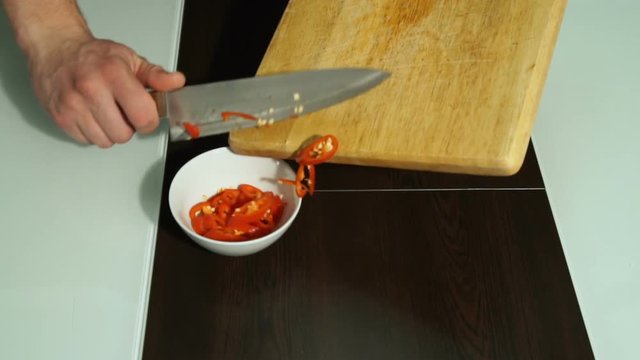 white male chef pours pepper into a plate