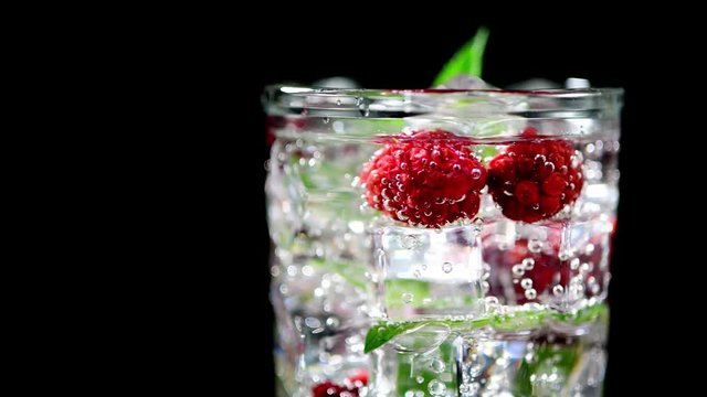 cold drink with blackberries and mint on a black background closeup