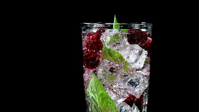 cold drink with blackberries and mint on a black background closeup