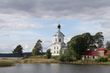 Fototapeta na wymiar Stolobny island, Nilov Monastery, Seliger lake in Russia seen from the lake, churches, clouds