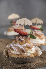 Homemade profiteroles with cream, strawberries and mint. Dessert for gourmets.