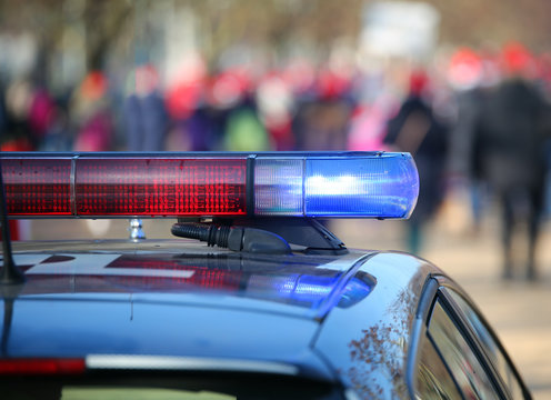 Police cars with sirens lit during the uprising through the stre