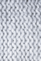 White Knitted woolen background. knitted warm clothes for the winter fabric texture background