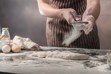 Man preparing buns at table in bakery