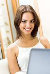 Fototapeta na wymiar Cheerfull smiling woman working with laptop