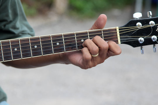 Young man hand playing acoustic guitar.